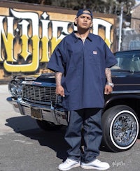 a man standing in front of a car with graffiti on it